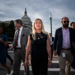 Greene walks away from the Capitol, crossing a street surrounded by others.