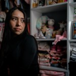 A portrait of Nayra Guzmán Zetina standing inside her home in Cicero, Illinois.