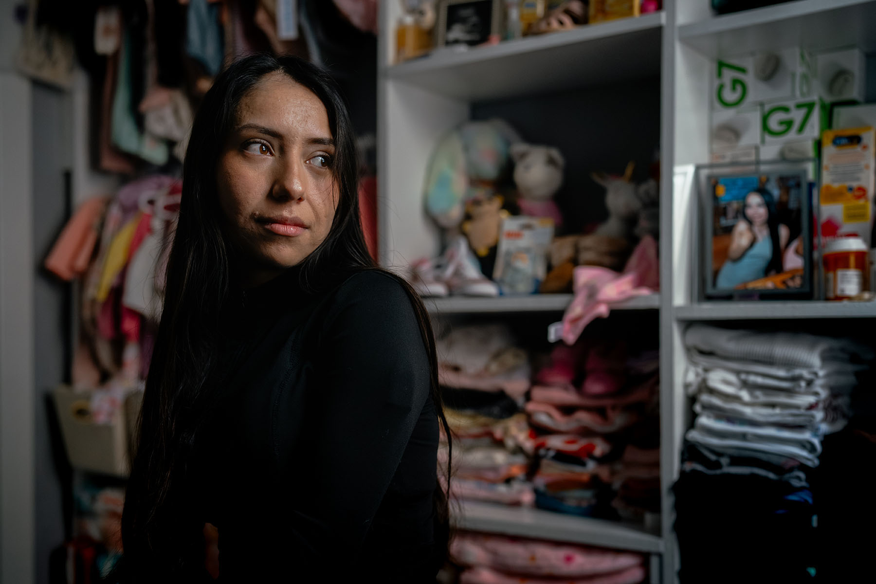 A portrait of Nayra Guzmán Zetina standing inside her home in Cicero, Illinois.