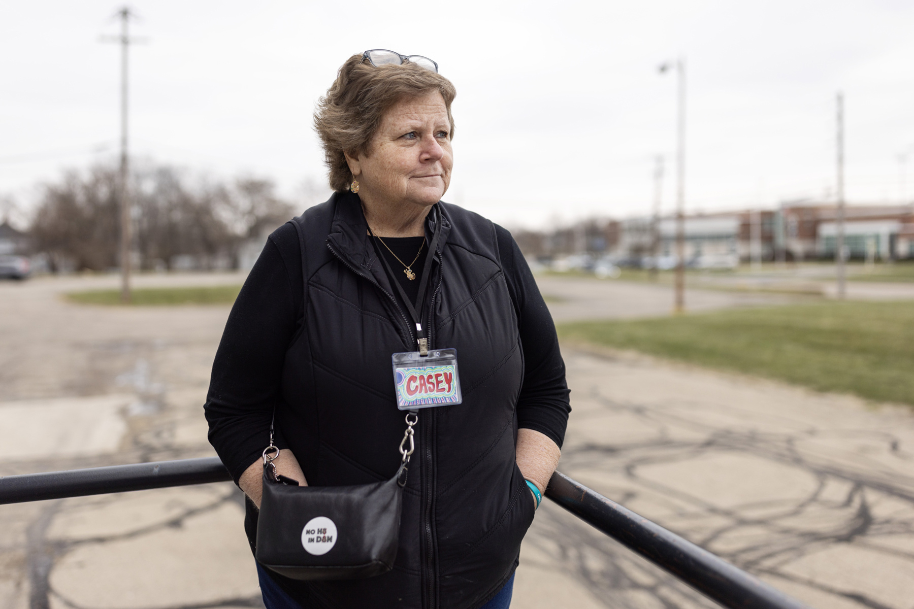 A woman stands outside with her hands in her pockets.