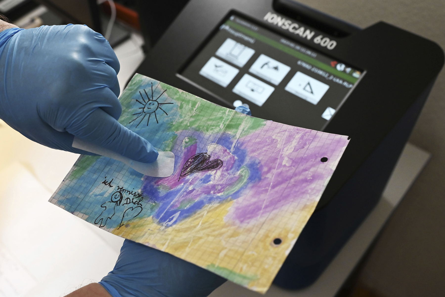 A person tests a drawing for drugs and prepares to scan it.