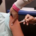 A child receives a vaccine from a doctor.