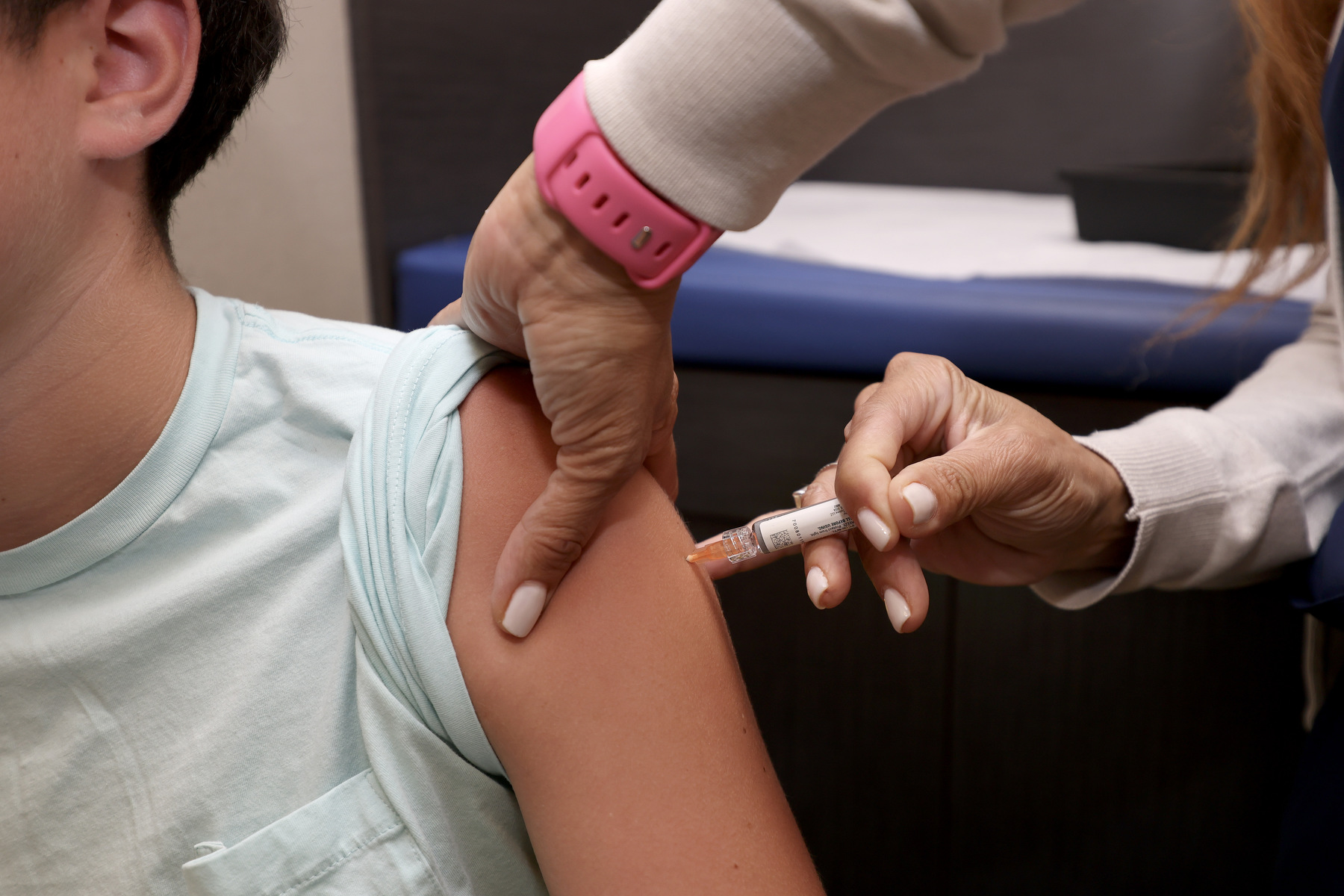A child receives a vaccine from a doctor.