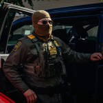 A federal agent stands near unmarked cars in Chicago, Illinois.