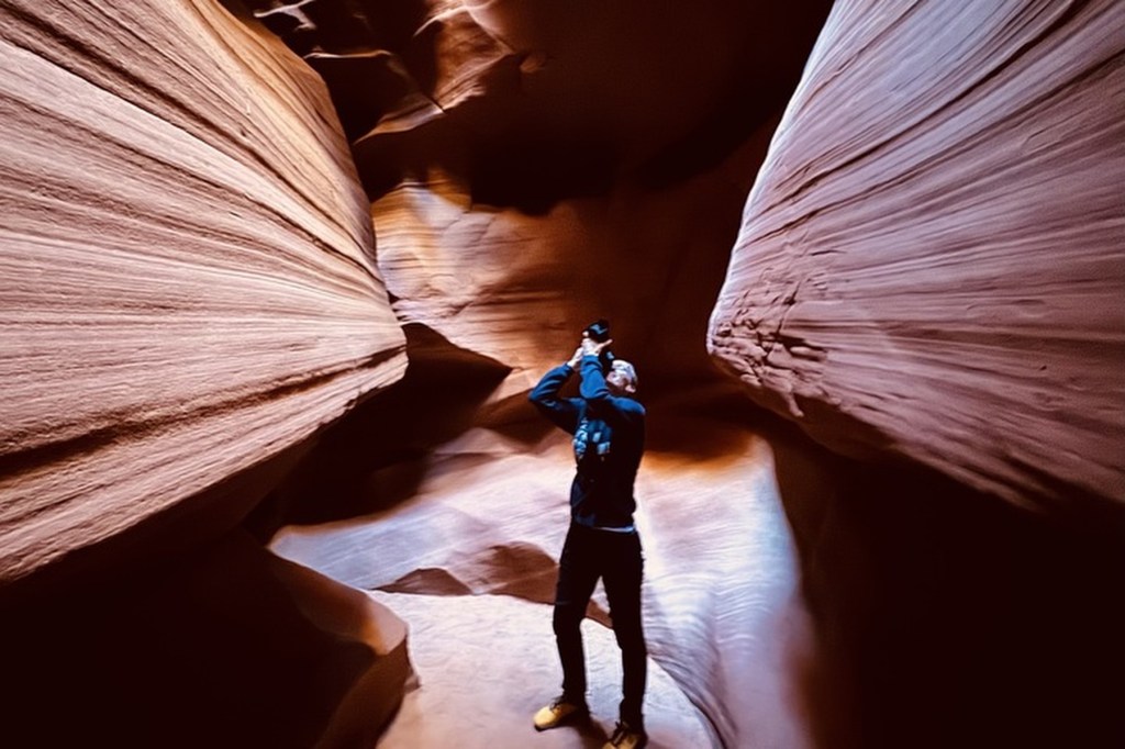 A woman takes photos in a cave.