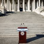 A podium saying save healthcare stands empty at the bottom of stairs.