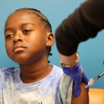 A young boy gets a COVID-19 vaccination in a medical center.