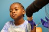A young boy gets a COVID-19 vaccination in a medical center.