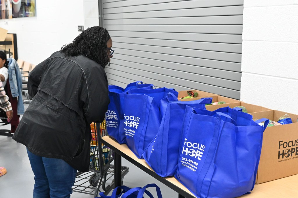 A volunteer inspects bags of food at Focus: HOPE in Detroit.