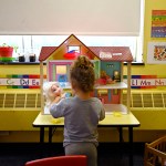 A child plays with dolls at a Head Start program at Alliance for Community Empowerment.