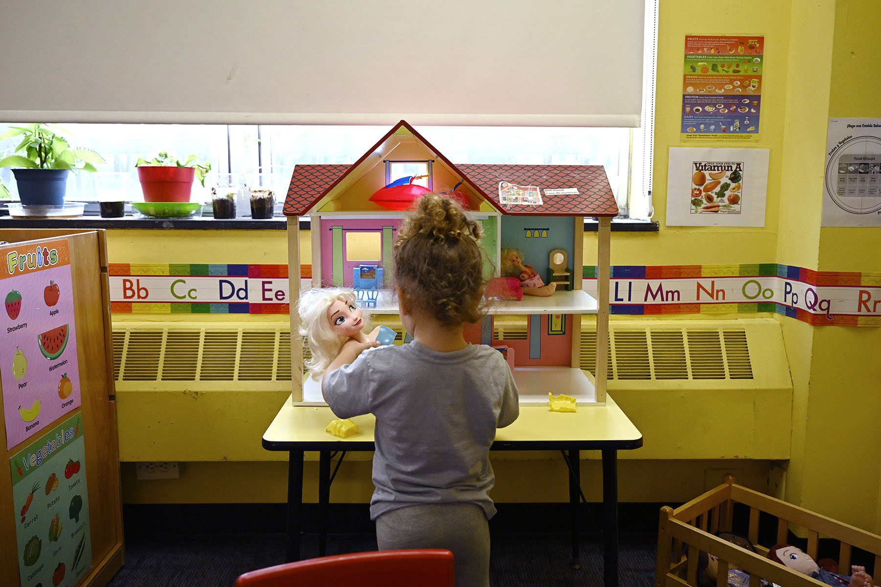 A child plays with dolls at a Head Start program at Alliance for Community Empowerment.