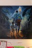 A painting of a father and son from behind surrounded by notes and a list of information in Creole on the wall.