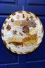 A wood carving of a map of Haiti hangs on a blue door.