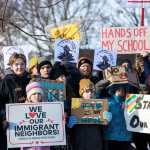 Minneapolis Public Schools families, educators and students hold signs protesting ICE and enforcement at schools
