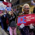 Nurses hold signs at a candlelight vigil and protest.