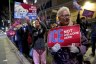 Nurses hold signs at a candlelight vigil and protest.