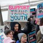 Supporters bundled in winter coats hold signs reading “Support trans youth” and “Protect trans mental health” at a rally at the Minnesota State Capitol in St. Paul, Minnesota, on March 6, 2022.