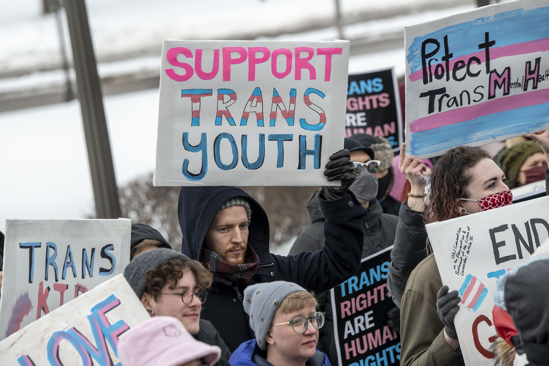 Supporters bundled in winter coats hold signs reading “Support trans youth” and “Protect trans mental health” at a rally at the Minnesota State Capitol in St. Paul, Minnesota, on March 6, 2022.