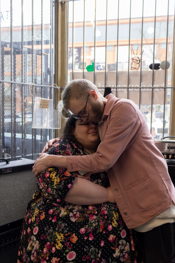 A man and woman hold each other close inside of a store.