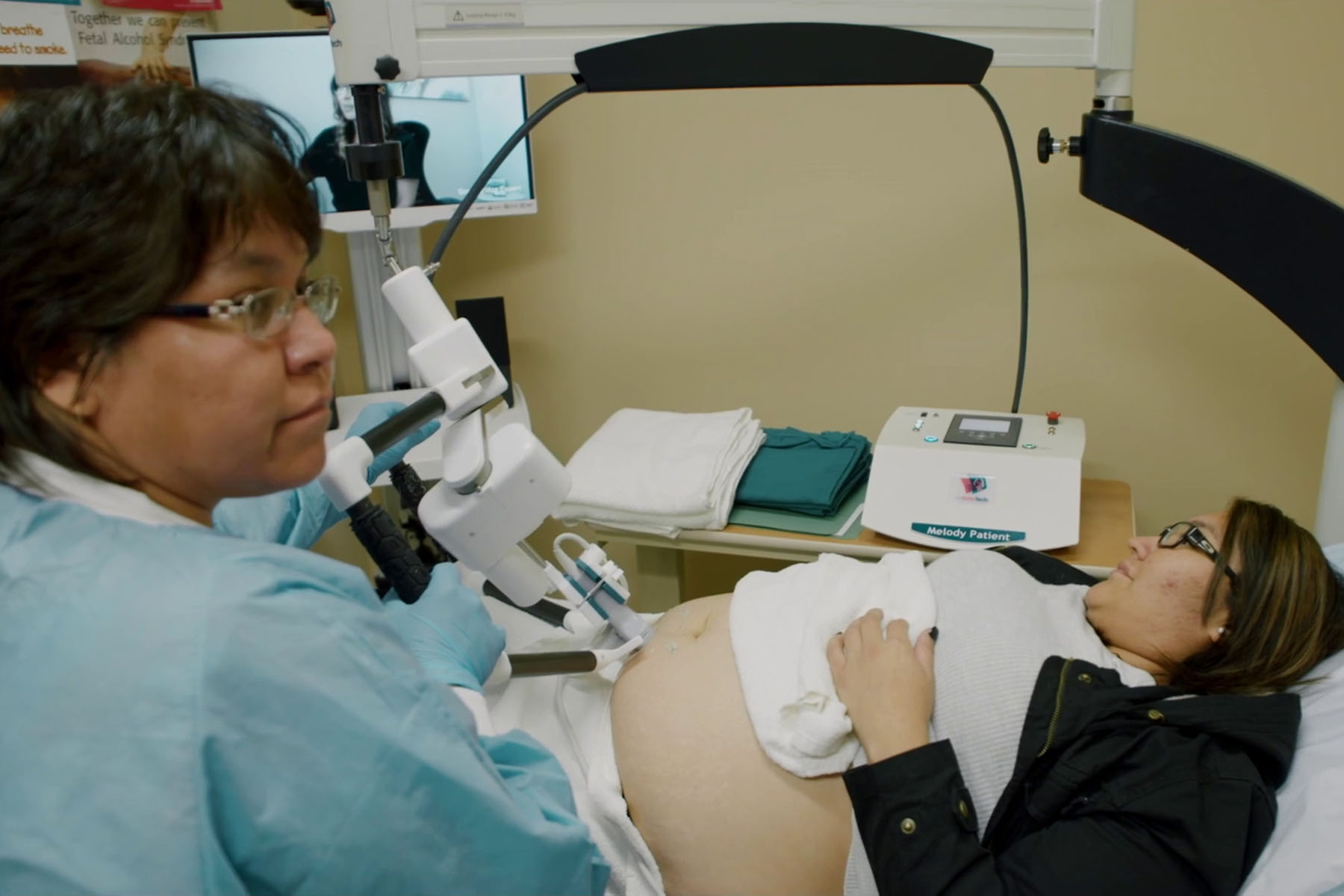 Technician Shawna Piche assists patient Trina Lobillard as she receives a remotely controlled ultrasound.