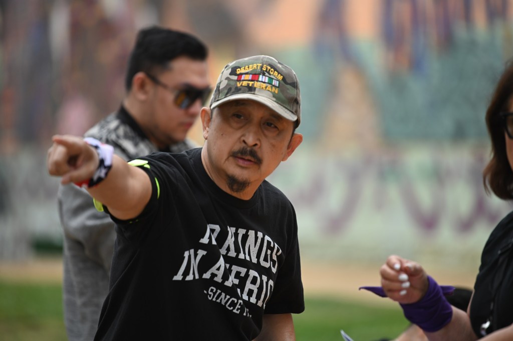 A man points to something out of frame, while wearing a military hat.