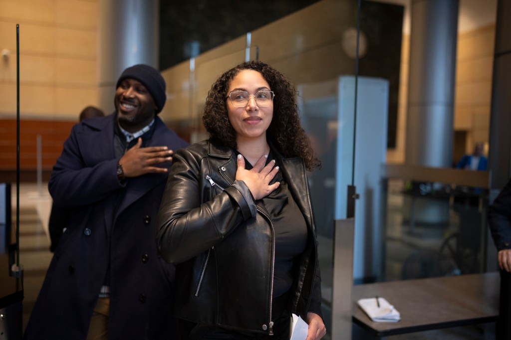 Fort walks out of a courthouse with her hand over her heart.