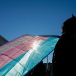 A person holds a transgender pride flag as they protest outside the Supreme Court in Washington, D.C