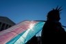 A person holds a transgender pride flag as they protest outside the Supreme Court in Washington, D.C