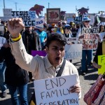 People protests against Immigration and Customs Enforcement as they march toward the South Texas Family Residential Center.