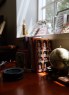 Books and objects sit on a desk near a window, including copies of The Making of Biblical Womanhood and a small globe.