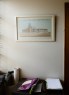 A framed drawing of a church building hangs on a wall above a desk with papers and supplies.