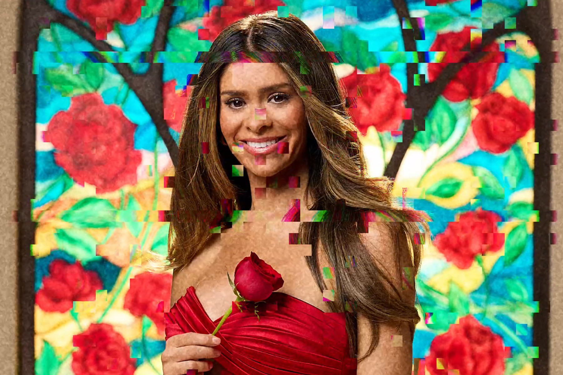 A woman with long brown hair smiles while holding a red rose, wearing a strapless red dress. She stands in front of a colorful painted backdrop of flowers, with visible digital glitch effects scattered across the image.