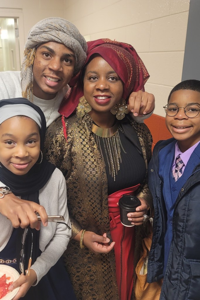 A family of four smiles at the camera.