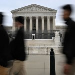 People walk by the Supreme Court of the United States.