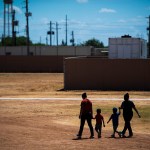Immigrant woman and children walk across a field as U.S. Immigration and Customs Enforcement hosts a media tour at the South Texas Family Residential Center in Dilley, Texas.