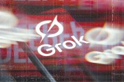 Stylized graphic showing the word “Grok” with a logo over a blurred, glitchy red and black background with streaks and digital distortion effects.