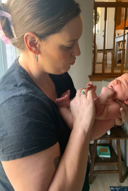 A woman holds an infant.