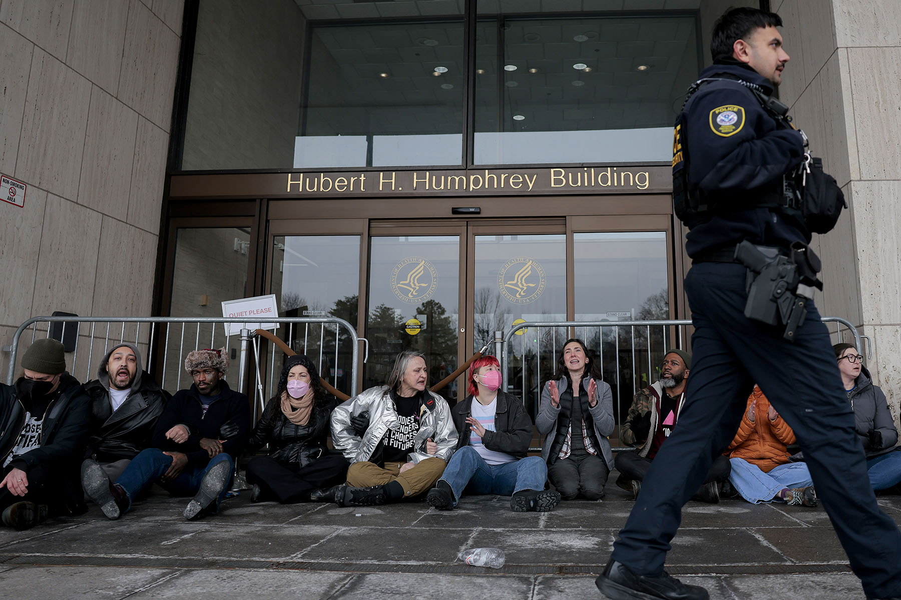Protesters with Gender Liberation Movement and ACT UP block the entrance to the Department of Health and Human Services while protesting the Trump administration’s plan to cut federal funding to clinics providing care for transgender youth.