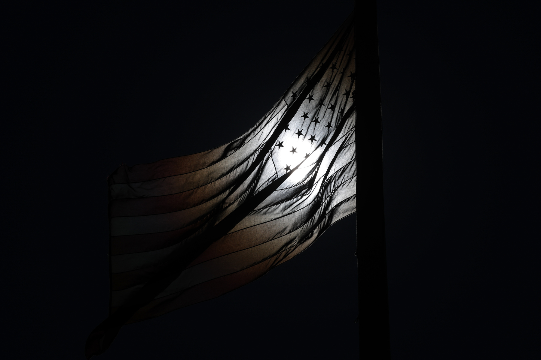 An American flag in shadow.