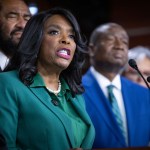 Rep. Terri Sewell speaks at a podium during a press conference, surrounded by other members of Congress.