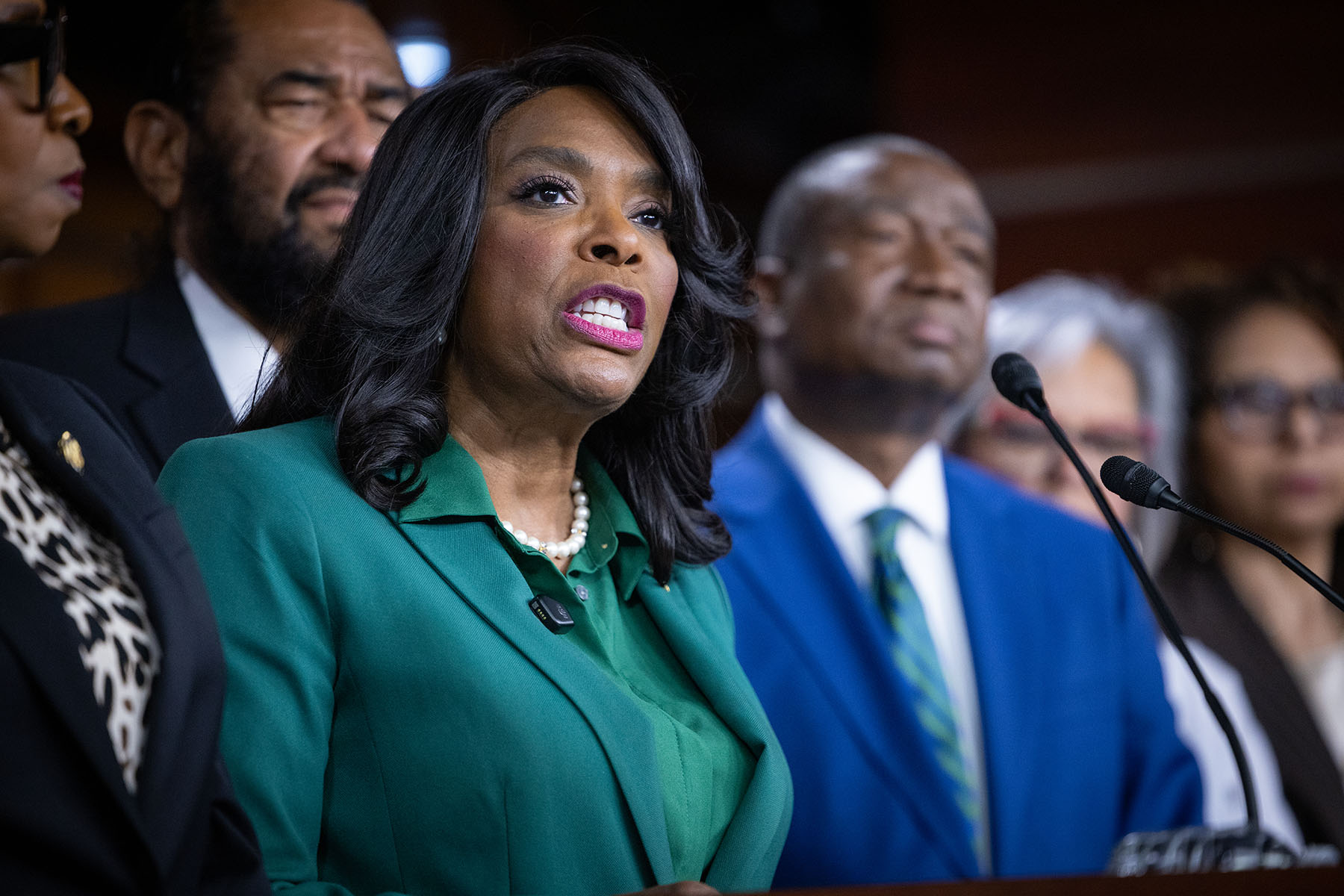Rep. Terri Sewell speaks at a podium during a press conference, surrounded by other members of Congress.