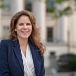 A portrait of the judge outside of a courthouse in a blazer.