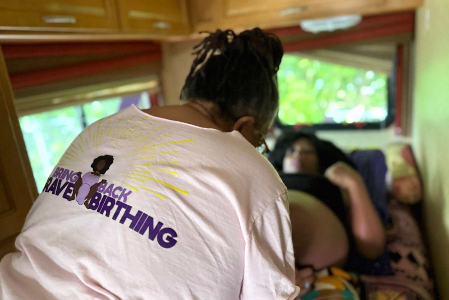Woman treating a patient during a pregnancy checkup inside a mobile midwifery clinic.