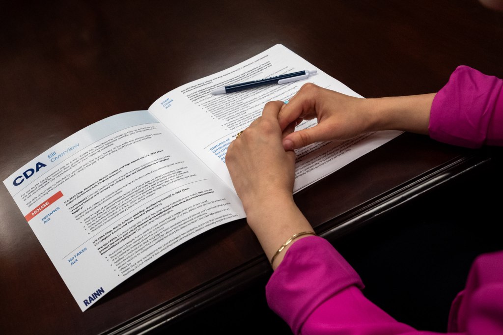 A closeup on hands atop an info sheet.