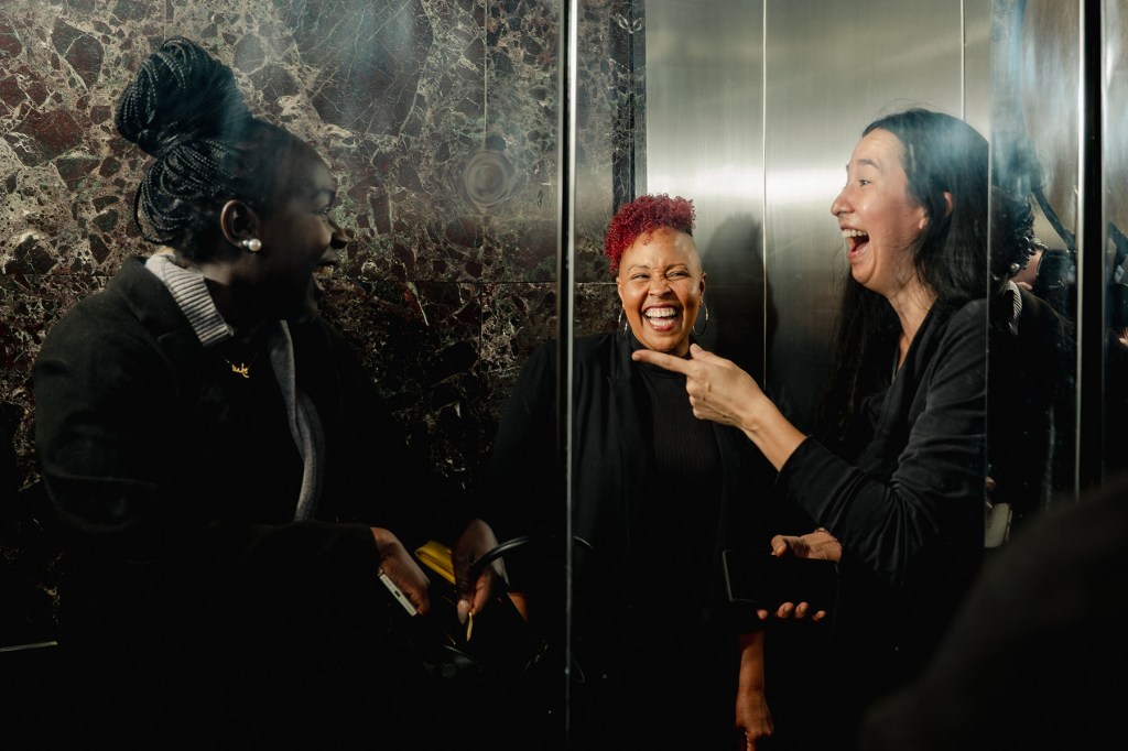 Allison Julien laughs with two other women near an elevator at the National Domestic Workers Alliance headquarters in New York City.