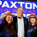 Texas Attorney General Ken Paxton stands between two supporters in Allen, Texas.