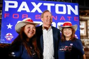 Texas Attorney General Ken Paxton stands between two supporters in Allen, Texas.
