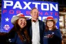 Texas Attorney General Ken Paxton stands between two supporters in Allen, Texas.