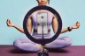 A person in lavender workout clothes sits cross-legged on a yoga mat behind a ring light and smartphone, with their arms extended in a meditation pose.