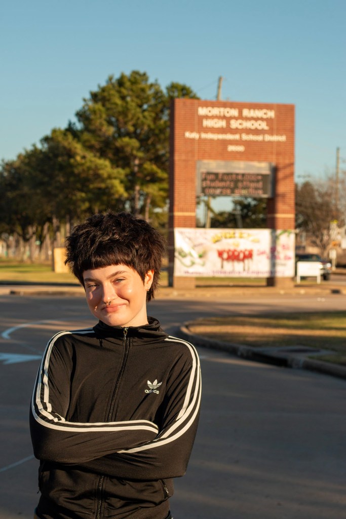 A student stands with arms crossed outside Morton Ranch High School.